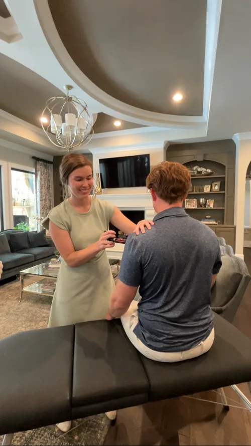 Dr. Sylvia treating a patient seated in their own living room